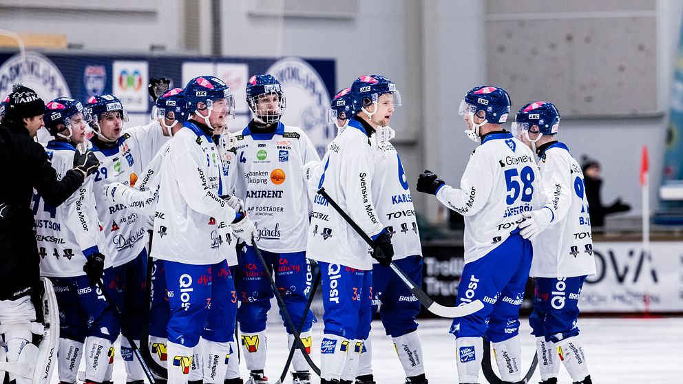 Spelare i vita tröjor tackar varandra efter matchen
