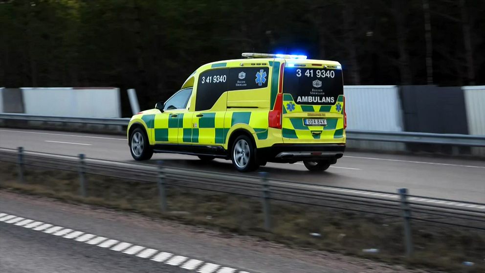 Ambulans med blåljus kör i hög hastighet på en landsväg.