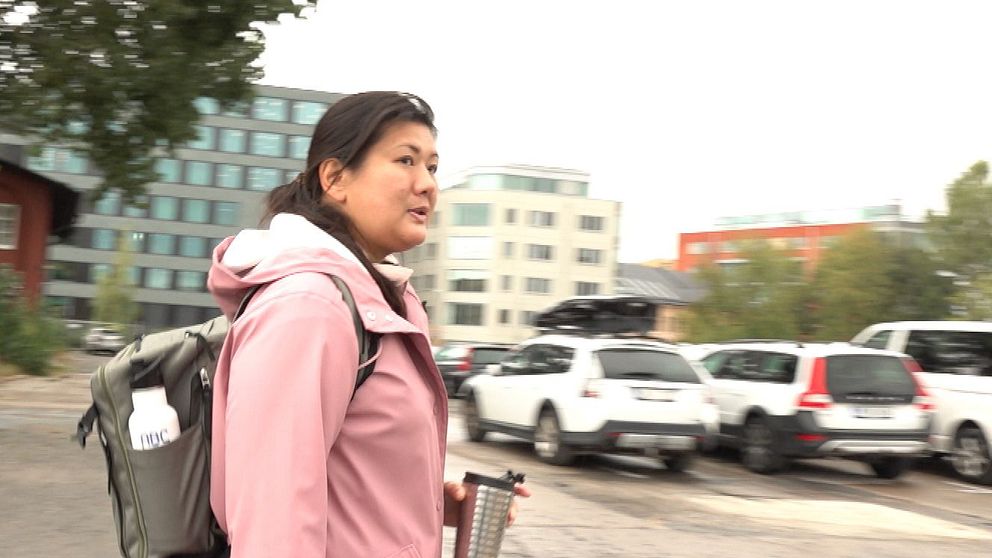 Kvinna som går på parkeringsplats.