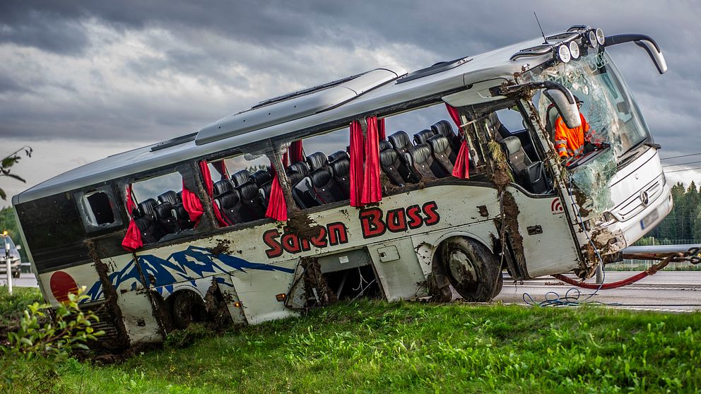 Buss bärgas längs väg 70 utanför Hedemora efter att ha vält och hamnat på sidan i diket. Alla fönster har krossats.