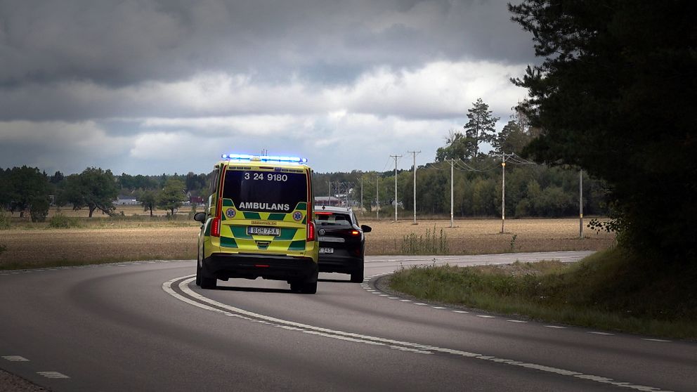 En ambulans under utryckning försöker köra om en bil.