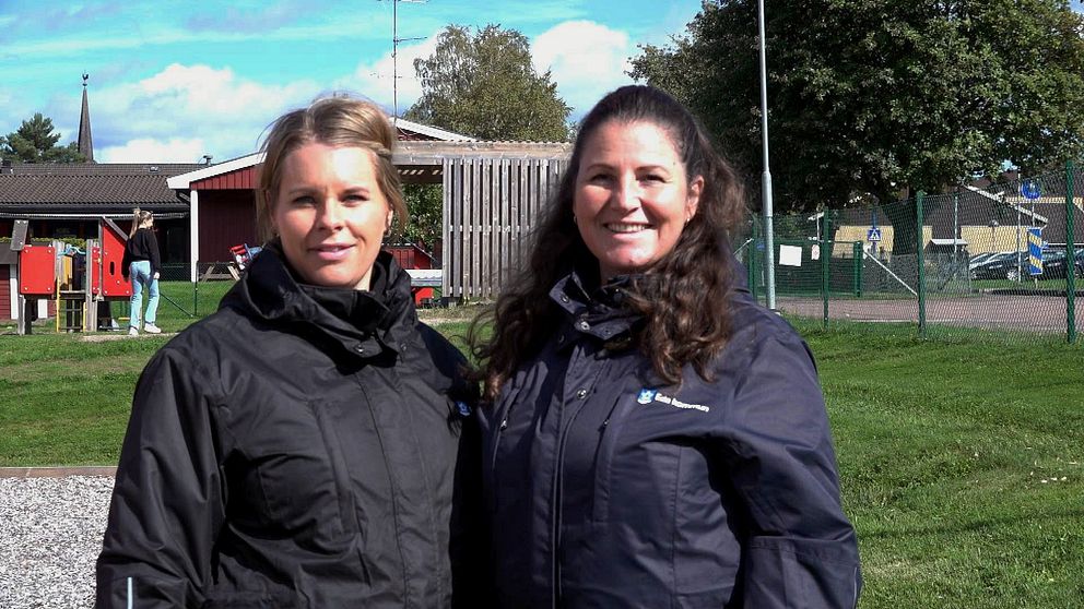 Två förskollärare utomhus i Eda med deras nya arbetsjackor.