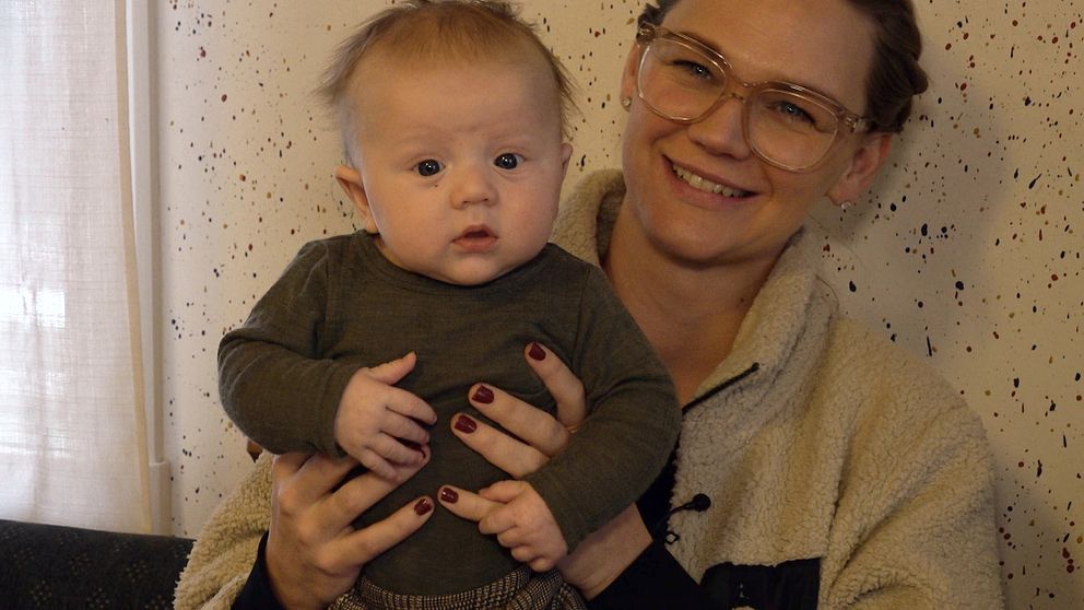 Christine Andersson sitter med sonen Frans i famnen på öppna förskolan i Vansbro.