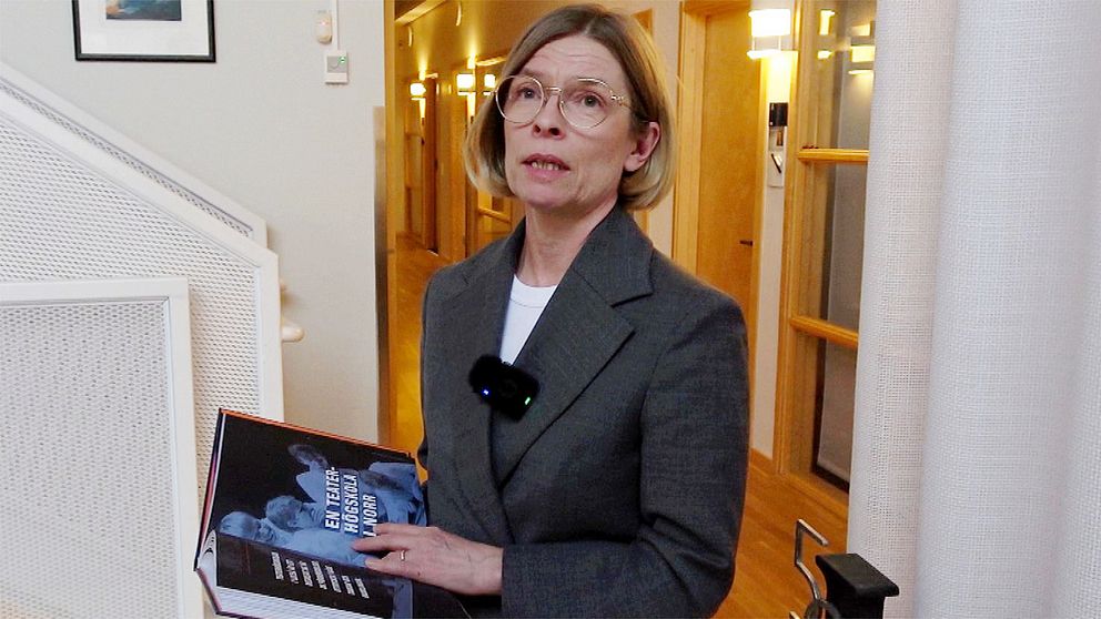Birgitta Bergvall-Kåreborn, rektor Luleå tekniska universitet, håller i en bok och tittar mot kameran. Hon är klädd i en grå dräkt.