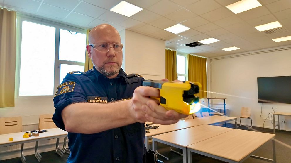 En polis håller det nya elchockvapnet framför sig.