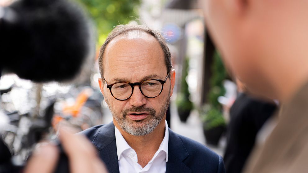 Intervju på gata mellan man i kostym och journalist med mikrofon.