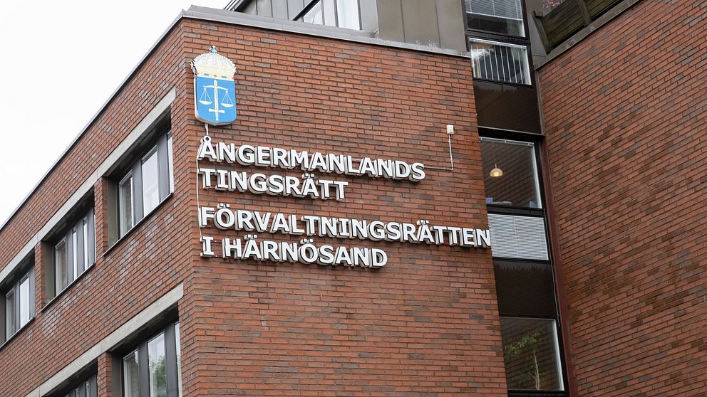 Fasad av byggnaden för Ångermanlands tingsrätt och Förvaltningsrätten i Härnösand, med röd tegelvägg och skylt med juridiskt emblem.