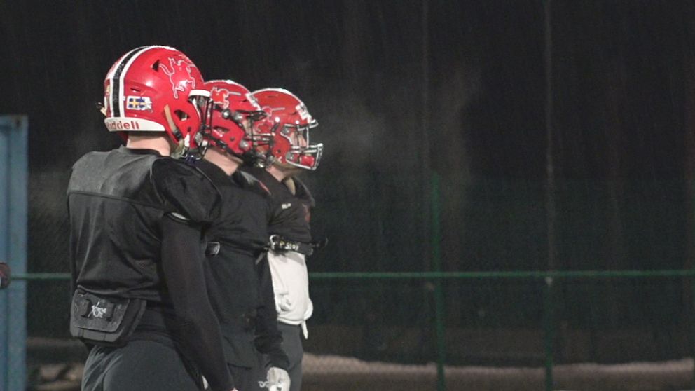 Tre av spelarna i Carlstad Crusaders andas ut på sidlinjerna innan nästa övning börjar