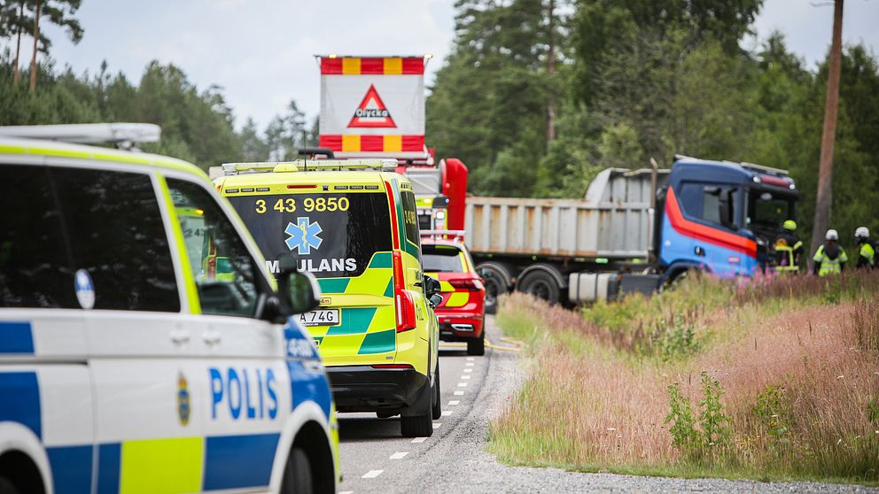 Räddningsbilar polis, ambulans och räddningstjänst amt en lastbil som står över vögen.