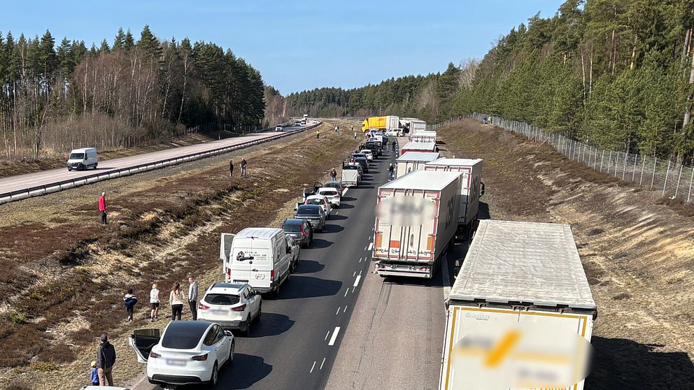 Lång trafikkö på motorvägen, bilar och lastbilar står stilla.