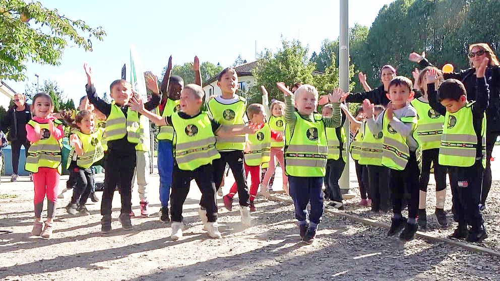 Barn i gula västar hoppar på förskolan i Kaxberg Södertälje