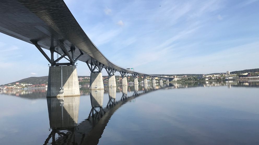 Sundsvallsbron sett underifrån en vacker sommardag. Vattnet ligger spegelblankt över sundsvallsfjärden