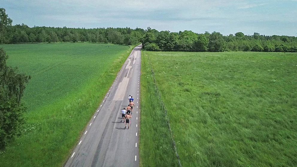 Skidlandslaget tränar med rullskidor på en tom landsväg. Drönarbild.