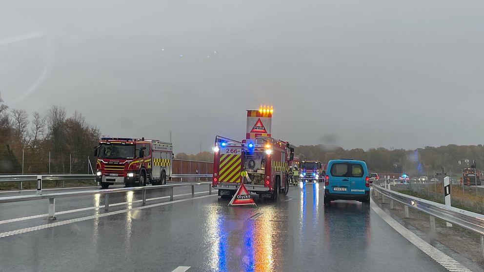 En trafikolycka i regnigt väder med flera utryckningsfordon på vägbanan.