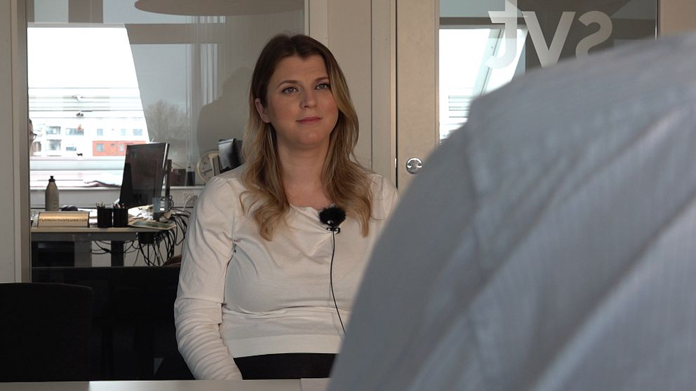 På bilden syns SVT:s reporter Valentina. Hon har en vit, långärmad tröja på sig. Vid andra sidan bordet sitter en person där en del av personens axel syns.