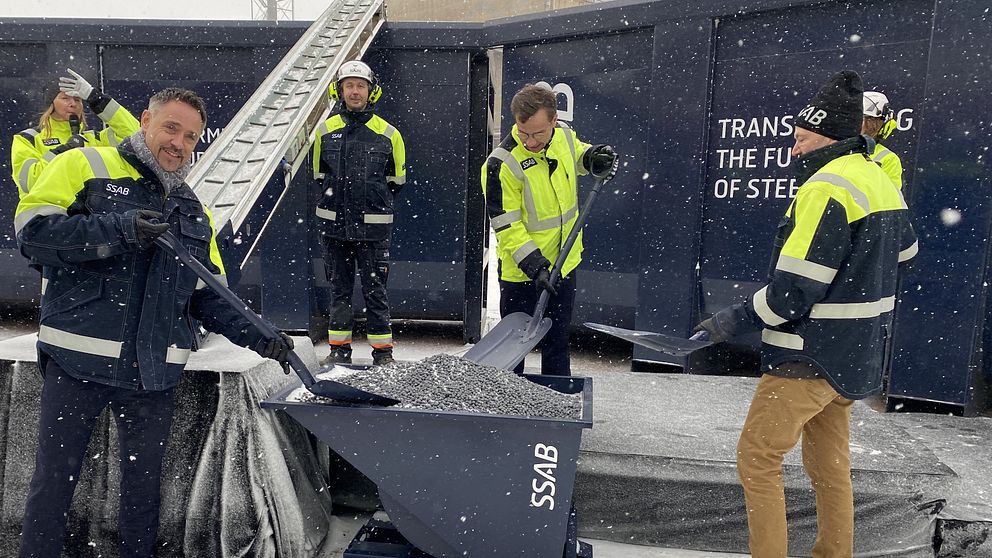 Statsministern och chefer på SSAB lastar över järnsvampen Hybrit på ett rullband.