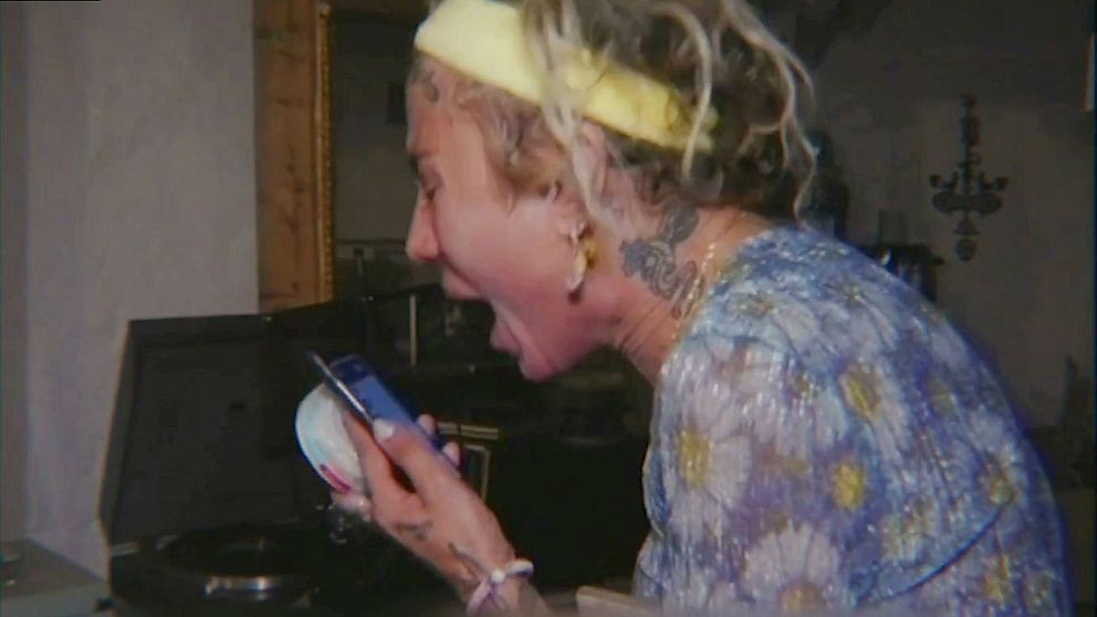 Bild ur filmen Megaheartz där en kvinna skriver mot en telefon.