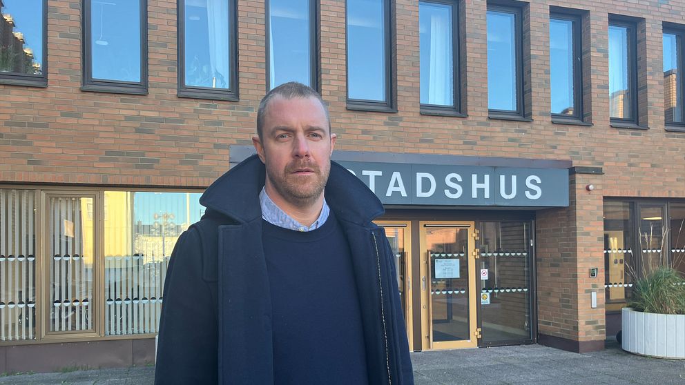 En man framför stadshuset i Vimmerby.