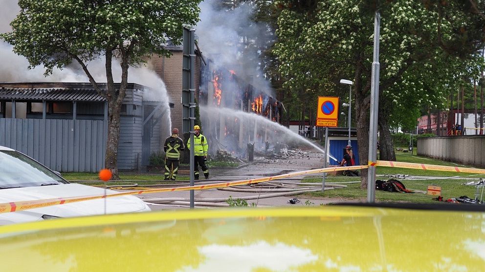 Brandmän vid det nedbrunna huset