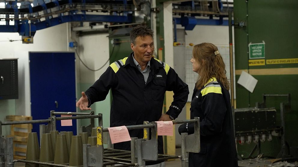 En man pratar med en kvinna i en fabriksmiljö