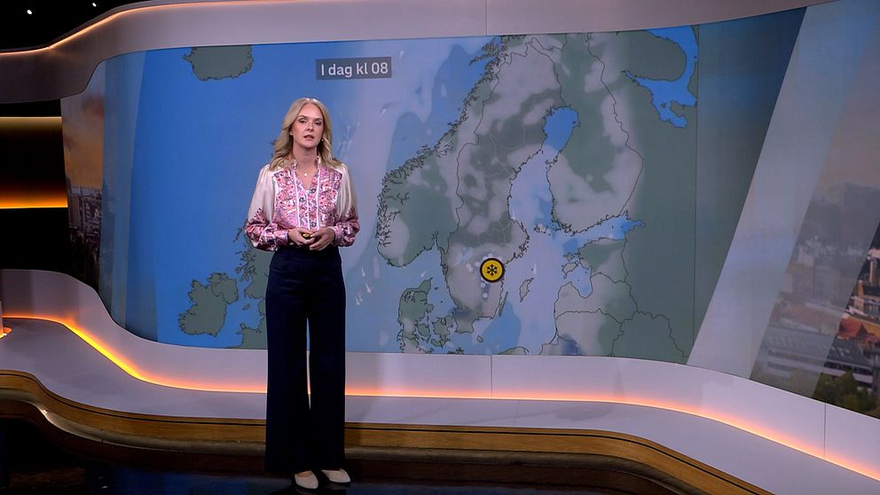 SVT:s meteorolog framför väderkarta med gul varning i Östergötland.