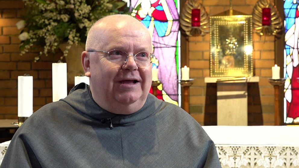 Pater Joseph Maria Nilsson står framför ett altare