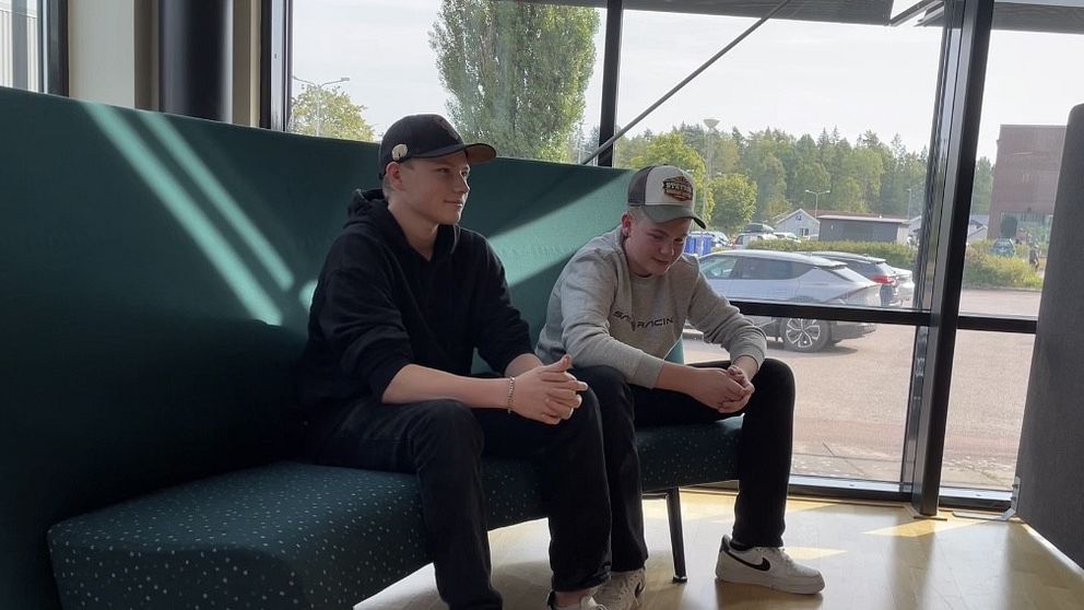 Två killar sitter i en soffa