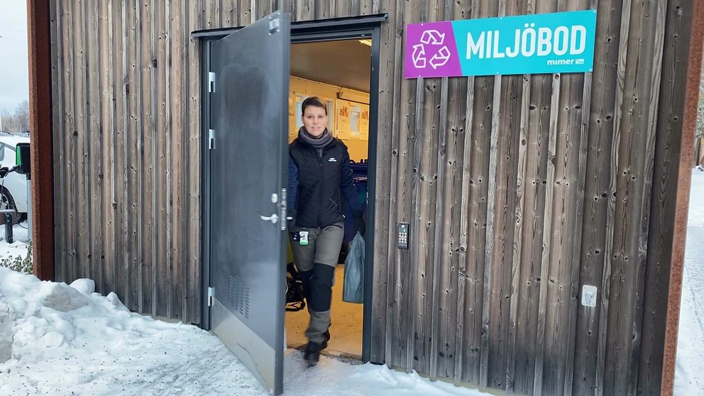 Kvinna som går ut ur ett soprum.