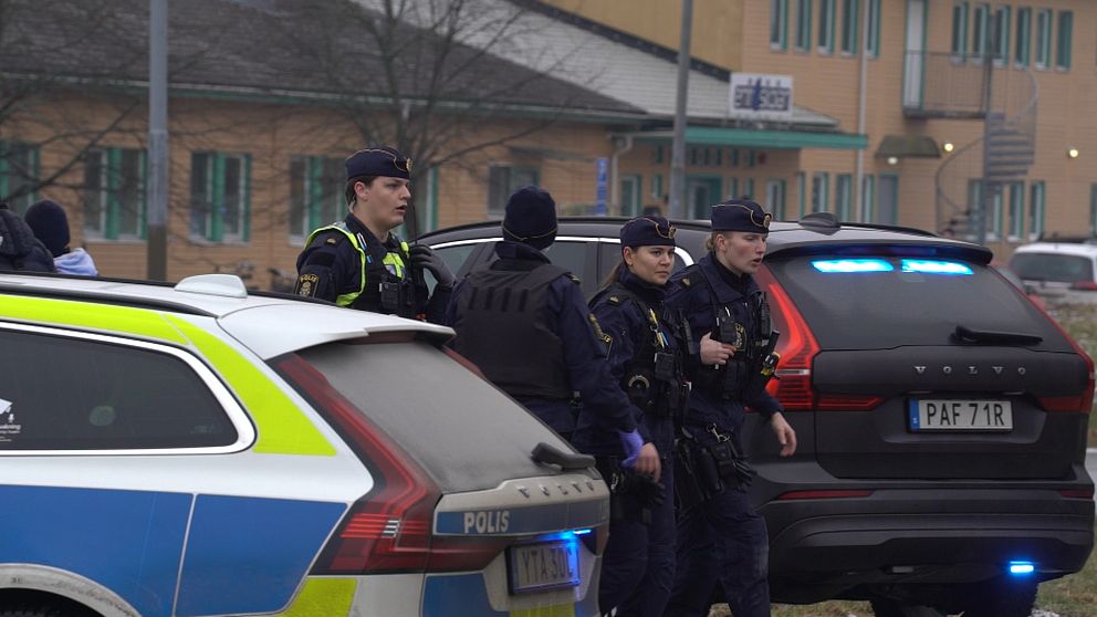 Poliser intill en polisbil utanför Risbergska skolan i Örebro, platsen där Rickard Andersson mördade tio personer i Sveriges värsta masskjutning genom tiderna.