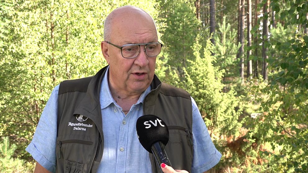 Ulf Berg i väst med jägarförbundets logga, skog i bakgrunden