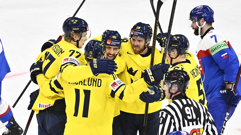 Svenska ishockeyspelare i gula tröjor firar mål mot ett lag i blå och röd utrustning.