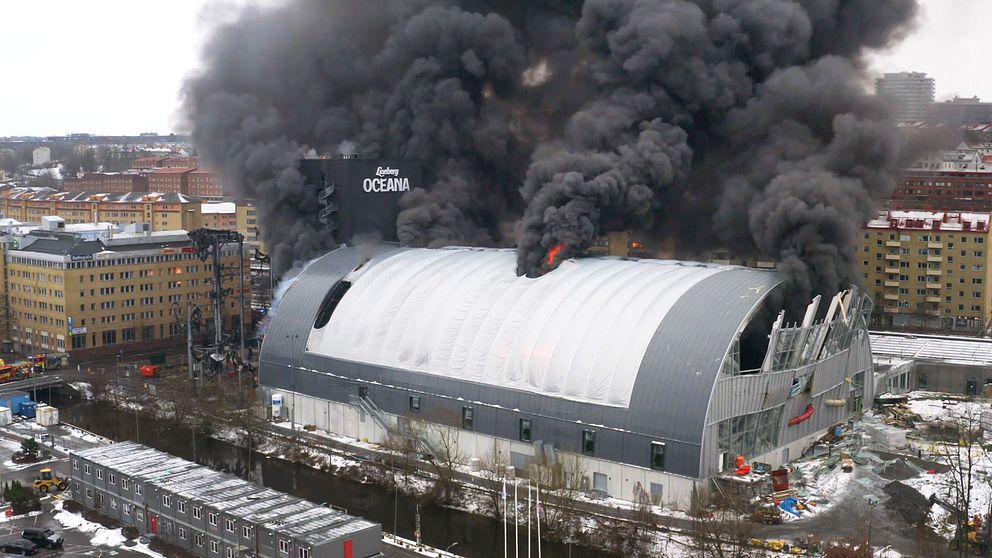 Liseberg Oceana, vattenpark stor byggnad i Göteborg, i brand med tjock svar rök som stiger upp mot himlen