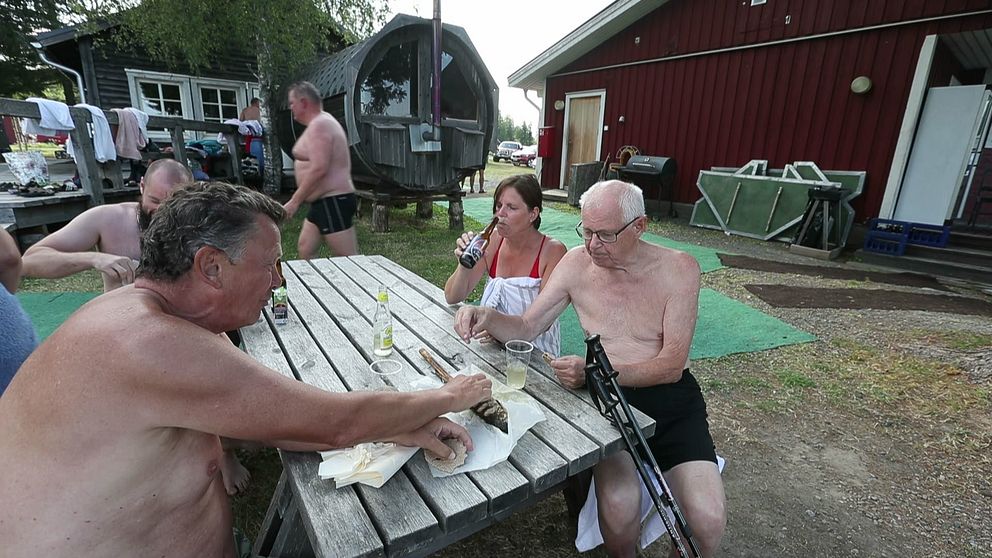 Finländarna utanför bastu. Halvnakna på fika på finskt sätt.