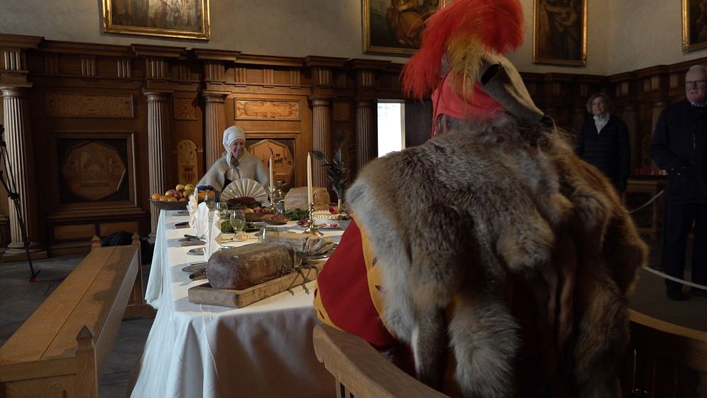 En man och en kvinna sitter vid ett bord och visar hur ett julfirande på Kalmar slott 1500-tal kunde se ut.