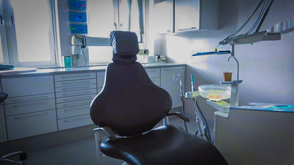 Tomt mottagningsrum hos tandläkare, en stol fotad i motljus