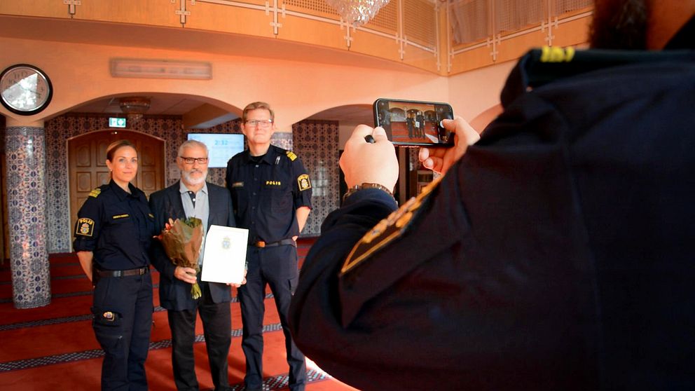 Polisen tar en bild tillsammans med Fittja Moskéns ordförande Ismail Okur. I handen har han diplomet som tack för samarbetet den 15 september 2023.