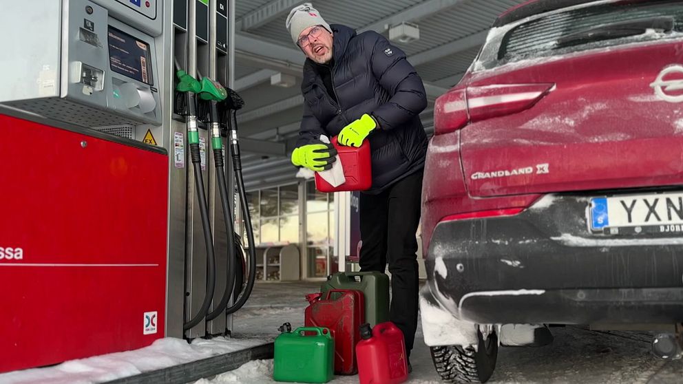 En man står och fyller dunkar med diesel på en mack i Umeå efter att priset sänkts.