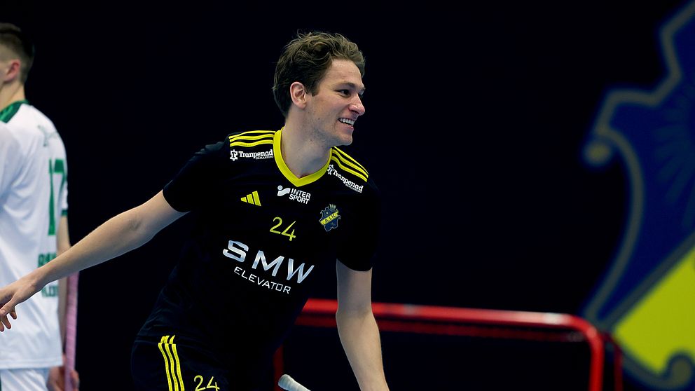 Innebandyspelare i svart dräkt med nummer 24 på planen.