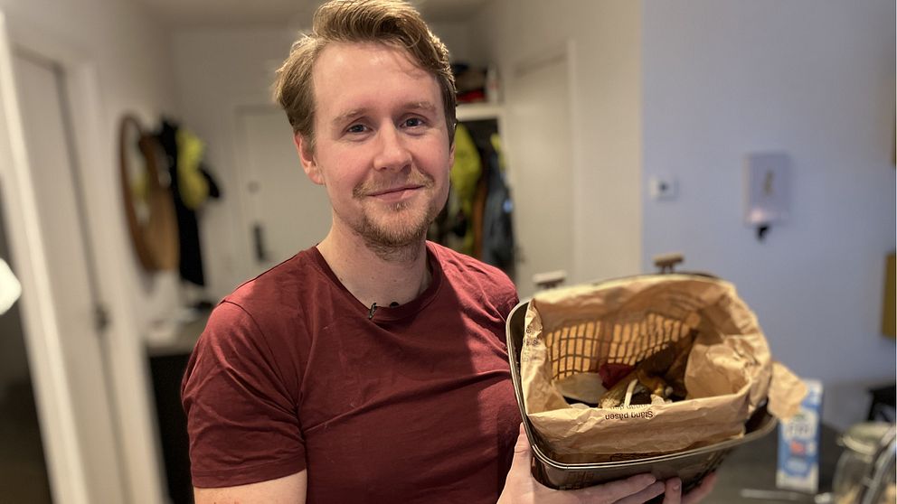 Man med matavfallspåse i handen.