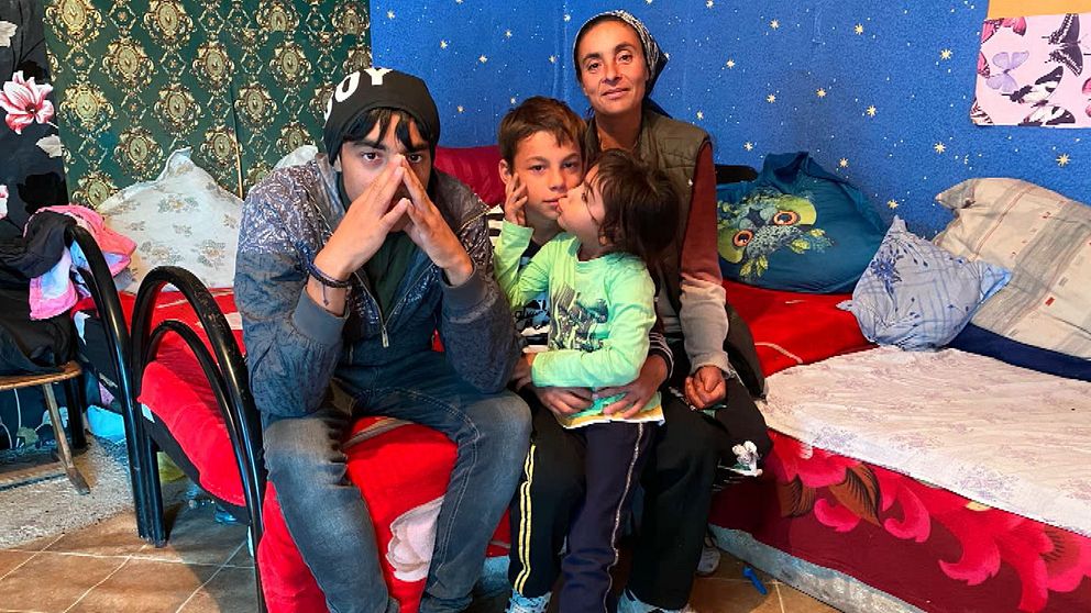 Romsk familj sitter i sängen i sitt hem i Valea Seaca i Rumänien. Bröderna går i skola men yngste brodern har drabbats av cancer