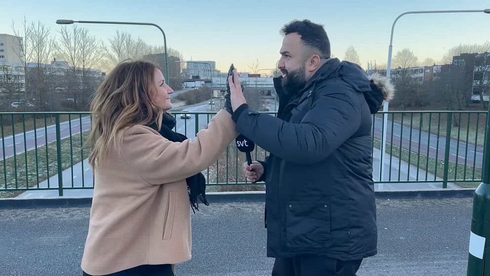 Fanny Berg och Hamza Ftouni gör high five på en bro över trafikerad gata.