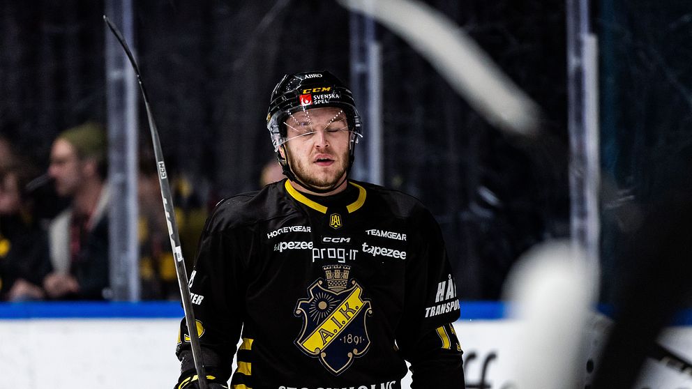 Hockeyspelare i AIK-tröja står på isen under en match.