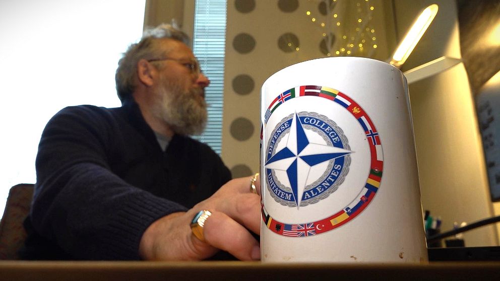 Forskaren Håkan Gunneriusson vid Mittuniversitetet sitter vid sitt skrivbord med en kaffemugg i förgrunden.