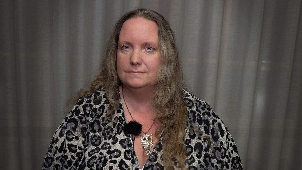 En kvinna sitter ned och tittar in i kameran
