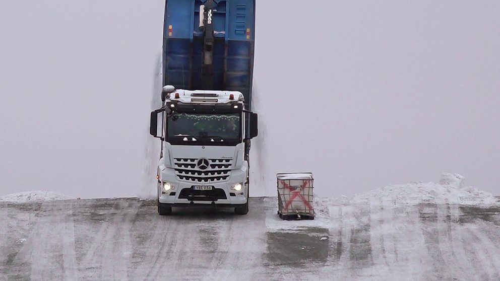 lastbil tömmer flaket på snö på Östersunds snötipp