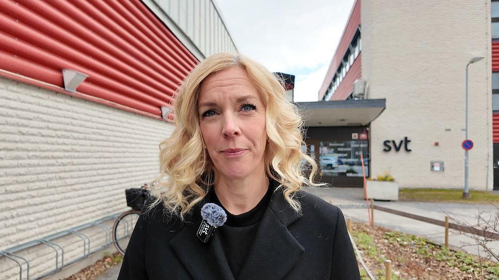 Person står utanför SVT:s byggnad, mikrofon synlig på rockslaget.