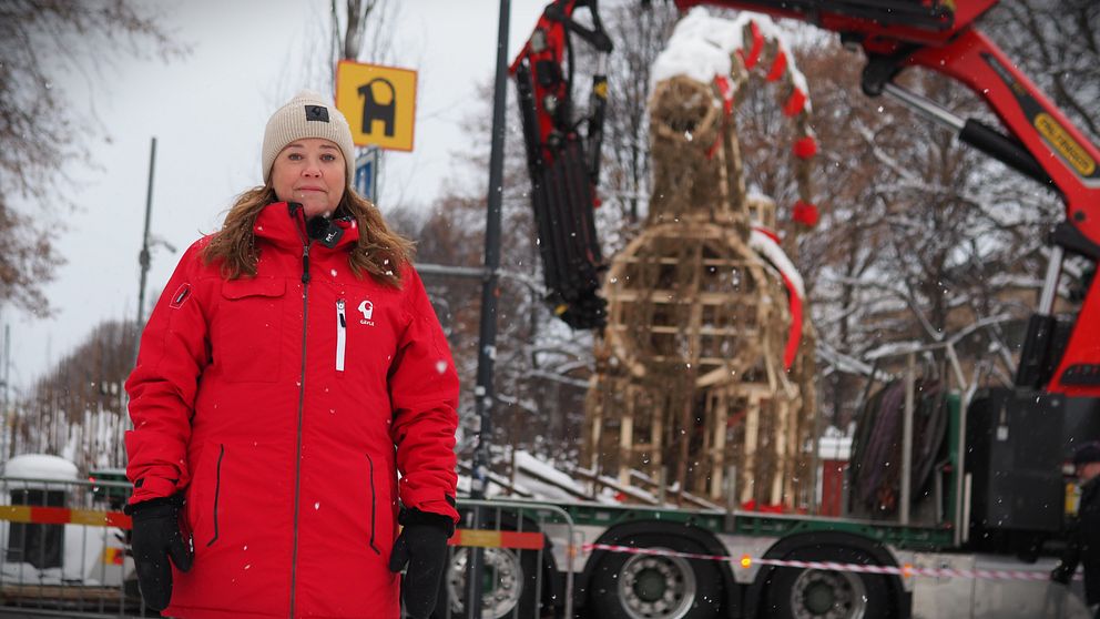 Kvinna står framför julbocken i Gävle.