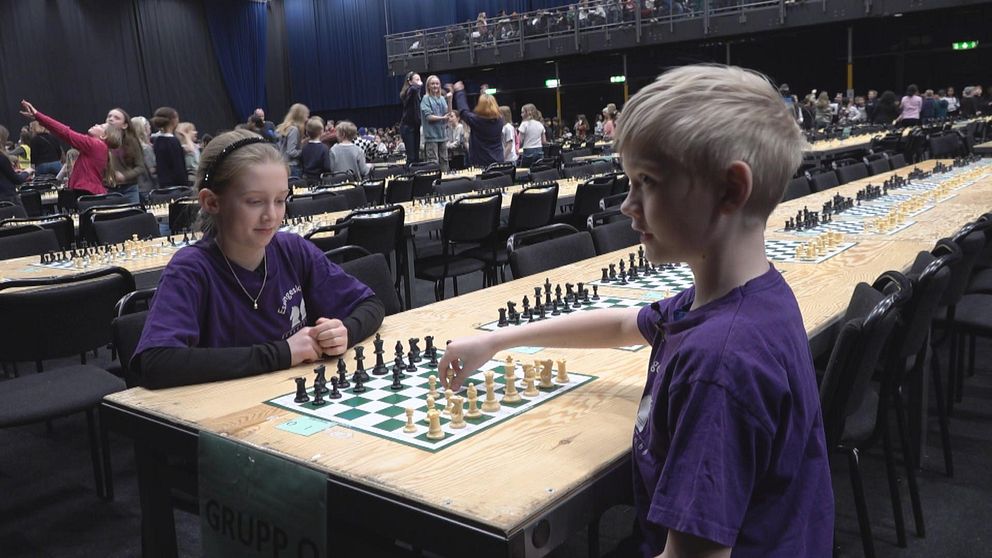 Två fjärdeklassare sitter mittemot varandra med ett schackbräde mellan dem.