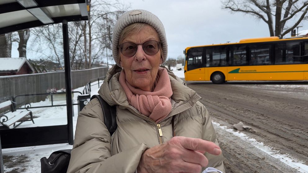en kvinna framför en busshållsplats