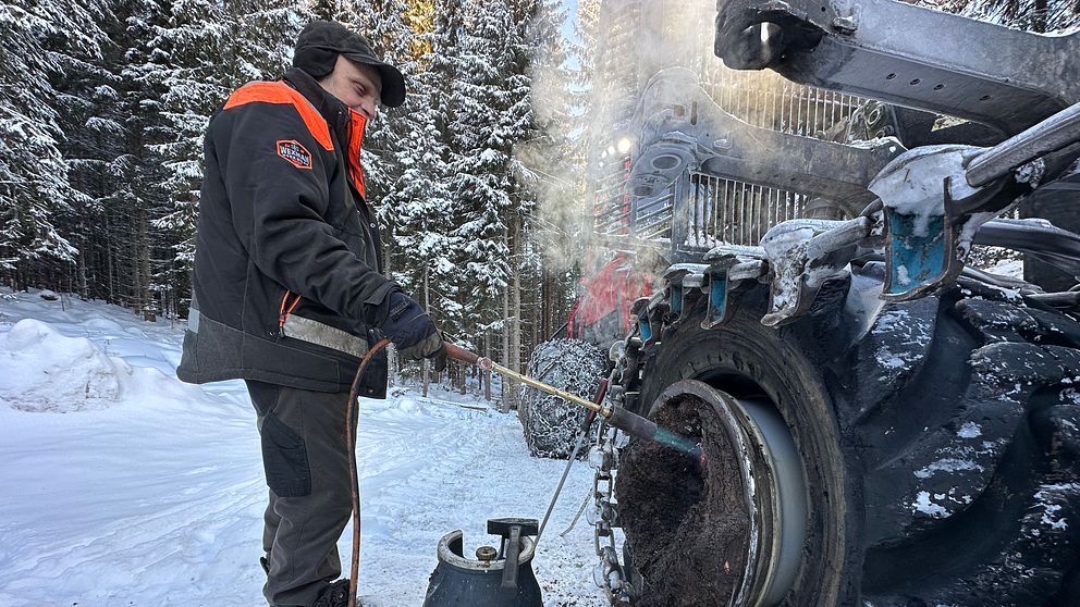 En man står vid en skogsmaskin